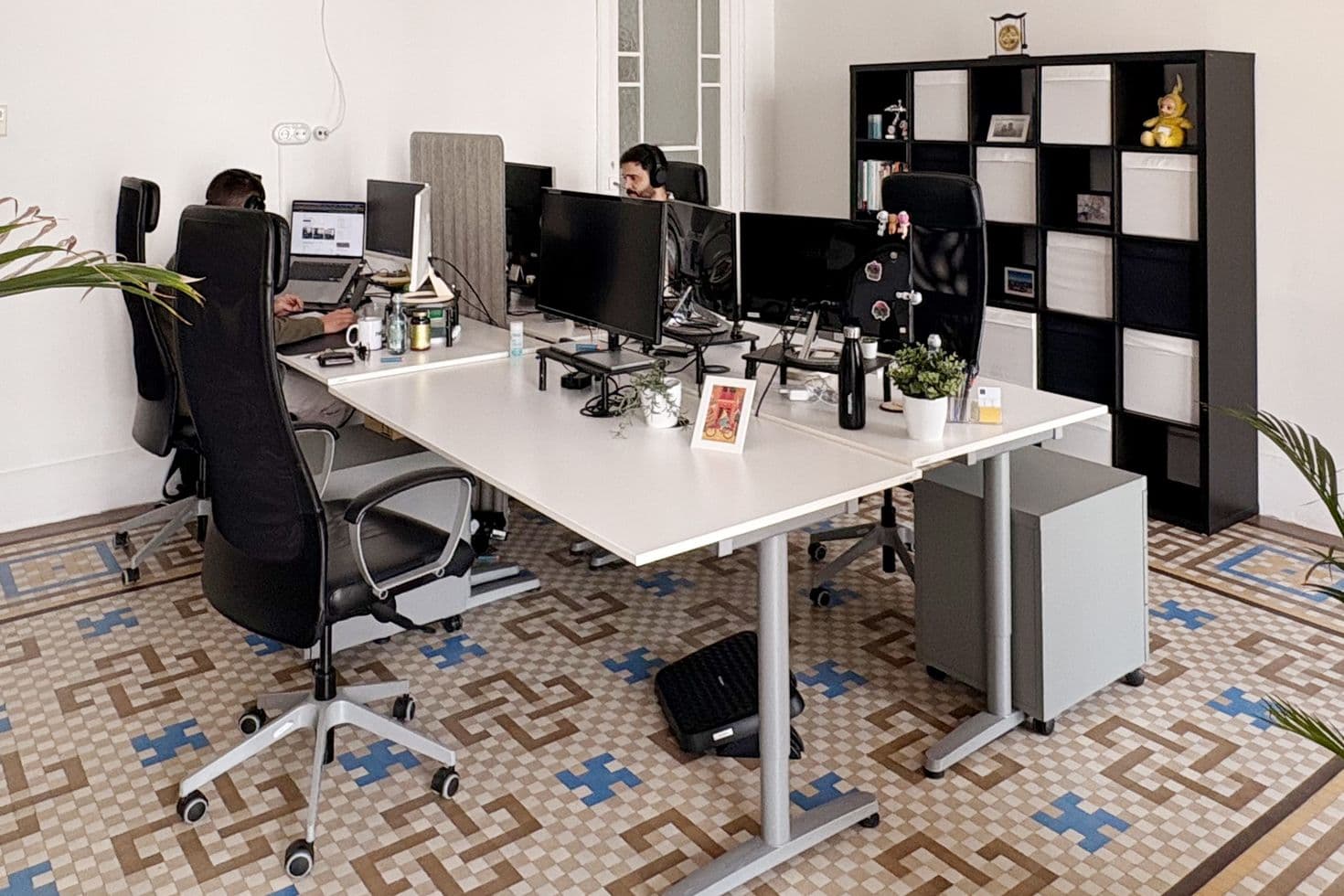 Innenansicht des Büros der nexum im spanischen València mit Mosaikfußboden, Schreibtischen und Regalen.